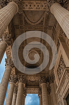 Perspective of the columns at the Pantheon entrance in neoclassical style and blue sky in Paris.